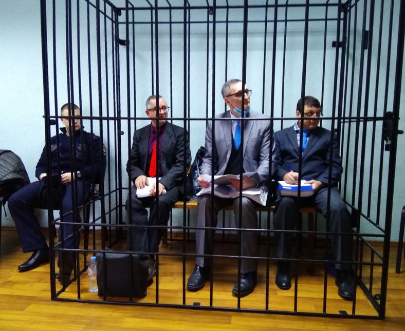 ウラジーミル・ピスカリョフ、ウラジーミル・メルニク、アルトゥール・プティンツェフは、オリョールでの裁判の間、檻に入れられた