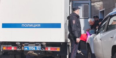 Anatoliy Odintsov, ammanettato, viene portato su un furgone di risero dopo il verdetto
